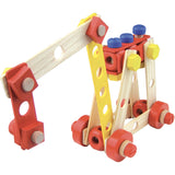 Wooden toy crane construction set made of colorful blocks, yellow nuts, and red wheels on white background.