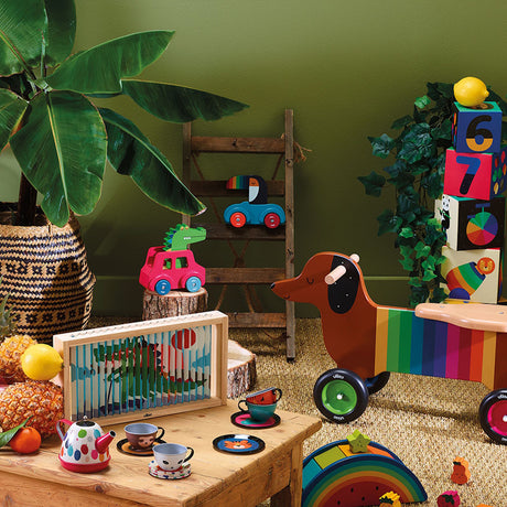 Vilac colorful wooden toys featuring a crocodile car, dachshund ride-on, and tea set in a playroom.