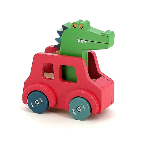 Vilac wooden toy crocodile driving a red car with blue wheels, side view isolated on a white background.