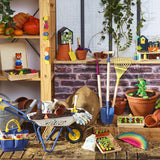 Kids' colorful garden tools, wheelbarrow, and wooden toys arranged on a rustic wooden patio.