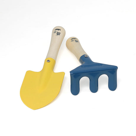 Vilac children's garden toy set with a yellow metal trowel shovel and a blue hand rake on a white background.
