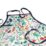 Childrens gardening apron with a colorful vegetable print, front pocket, and dark blue trim.