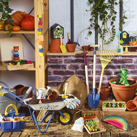 Vilac kids gardening toys display with a wheelbarrow, shovel, rake, tool bag, and potted wooden plants.