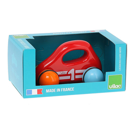 Red Vilac wooden baby car toy with handle and colorful wheels inside its blue retail packaging box.