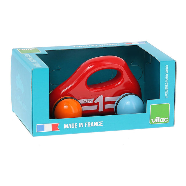 Red Vilac wooden baby car toy with handle and colorful wheels inside its blue retail packaging box.
