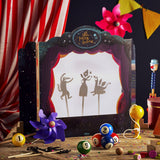 Tabletop shadow puppet theatre showing fairytale silhouettes on screen surrounded by colorful toys.