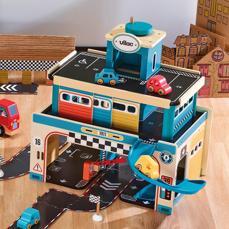 Vilac multi-story wooden toy garage with colorful cars, ramps, and parking levels on a play mat.