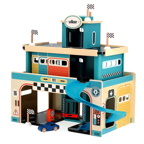 Vilac vintage wooden toy car garage with blue slide, race flags, gas station, and blue toy car on white background.