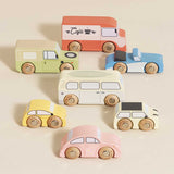 Set of seven vintage-style wooden toy vehicles arranged on a beige background.