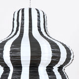 Close-up of a black and white vertically striped paper lantern showing detailed texture.