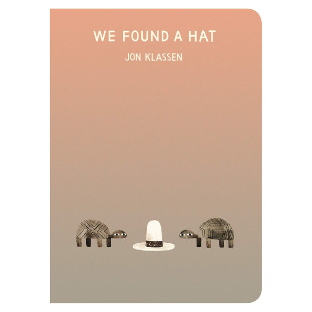 Book cover for We Found a Hat by Jon Klassen featuring two turtles looking at a tall white hat on a tan gradient background.