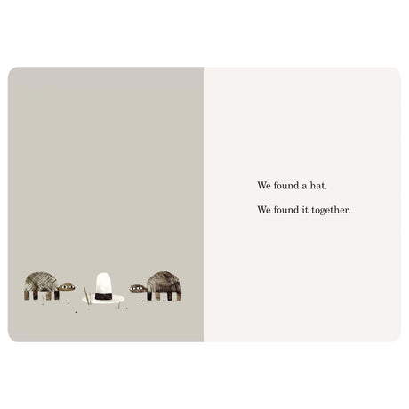 Two turtles stand next to a tall white hat with a black band. Text says, "We found a hat. We found it together."