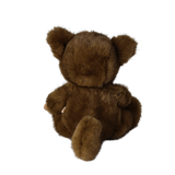 Back view of a seated plush doll in a fuzzy brown werewolf costume showing its tail and ears.