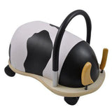 Rear-right view of the cow Wheely Bug ride-on toy, showing its curved black handle, black-and-white patterned body, and wooden base.