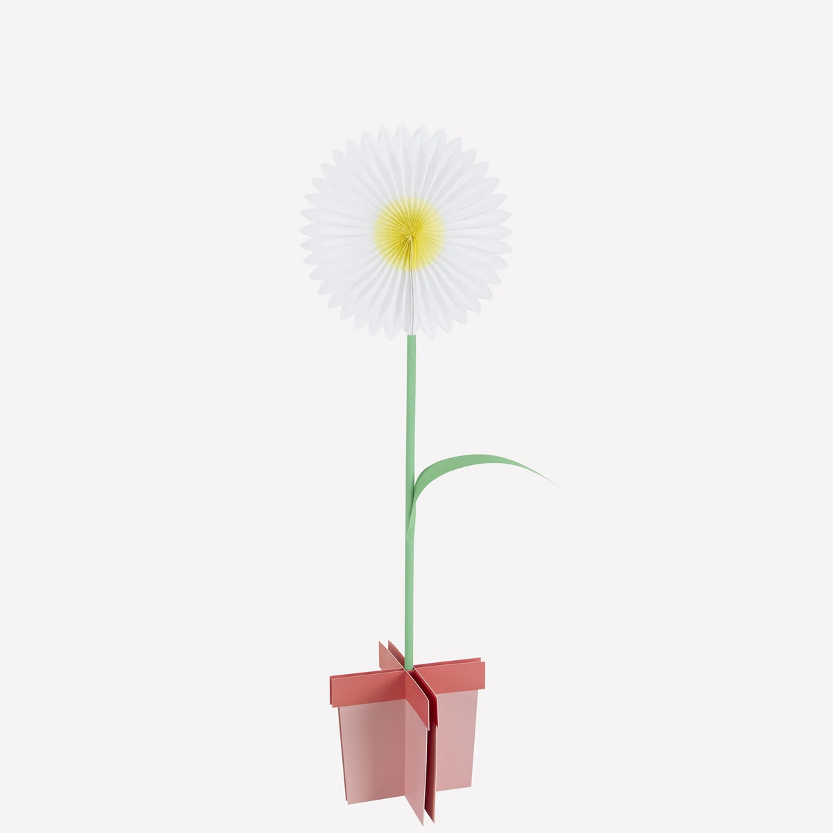 A stand-up paper flower decoration with white petals, a yellow center, and a pink base stand.