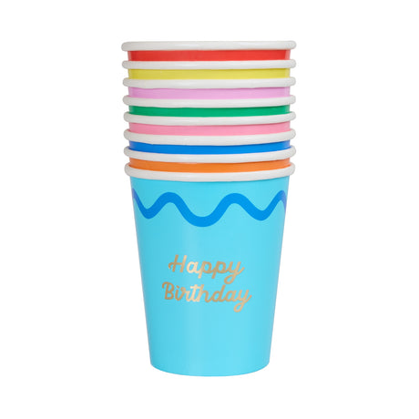 Stack of colorful paper cups with a blue "Happy Birthday" cup on the bottom on white.