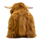 Fluffy brown plush toy resembling a Highland cow, with long fur and curved horns, set against a white background, conveying a cozy and whimsical feel.