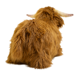 Fluffy brown plush toy resembling a Highland cow, with long fur and curved horns, set against a white background, conveying a cozy and whimsical feel.