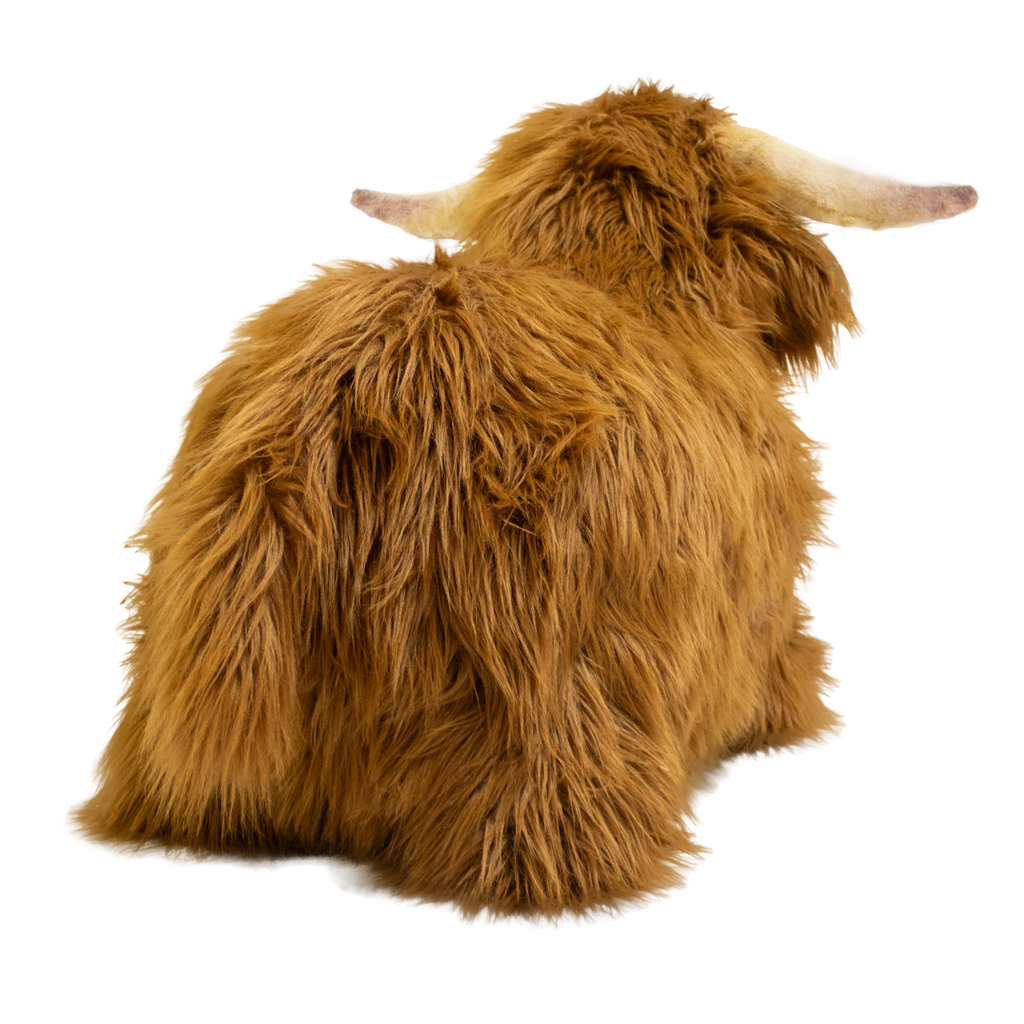 Fluffy brown plush toy resembling a Highland cow, with long fur and curved horns, set against a white background, conveying a cozy and whimsical feel.