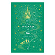Book cover of The Wizard of Oz by L. Frank Baum featuring a yellow brick road, Emerald City, and character silhouettes.