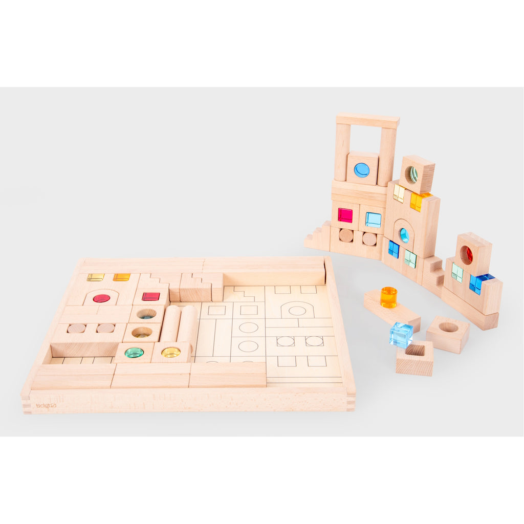A large collection of wooden construction blocks with embedded colorful gems, designed to encourage creative building, light play, and sensory exploration.