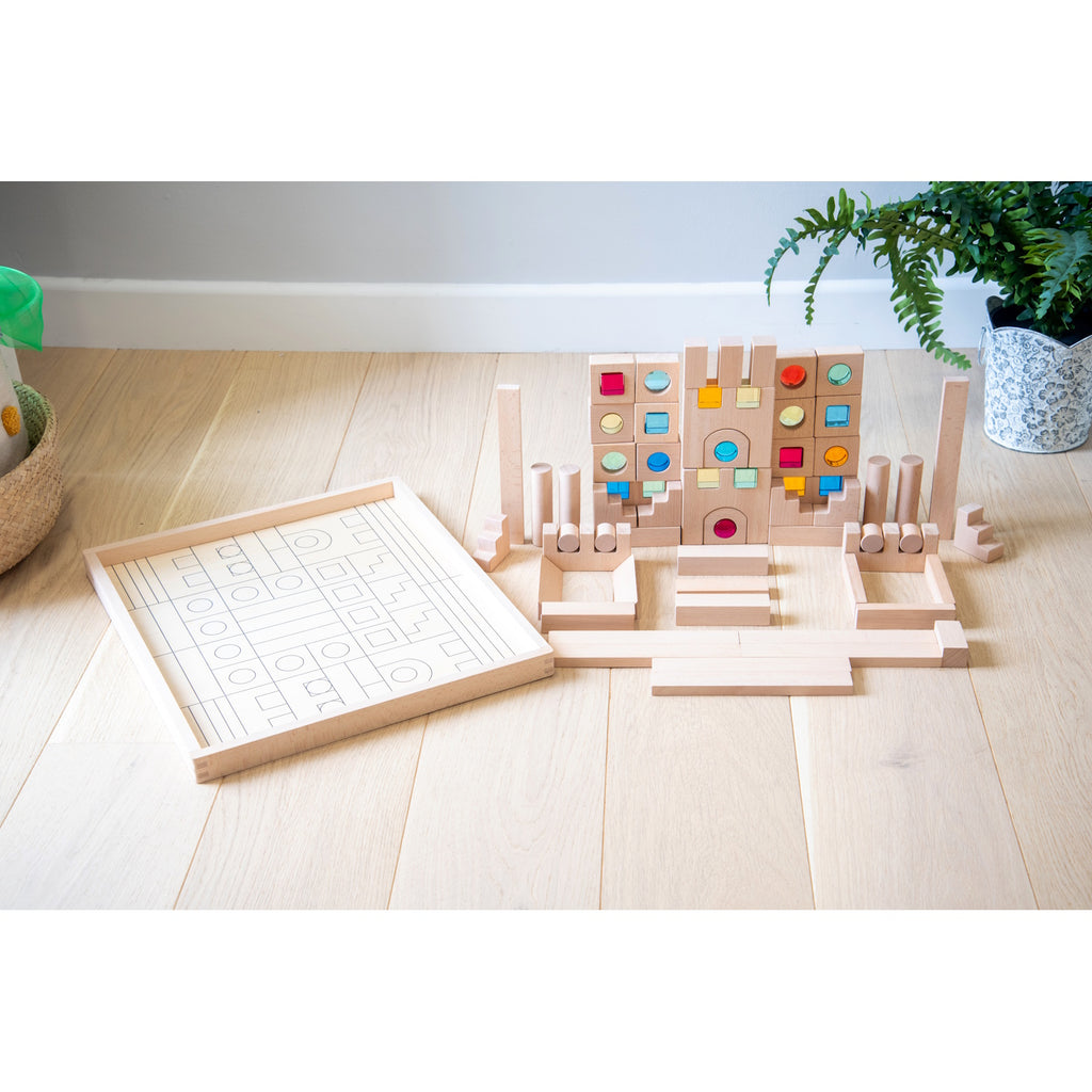 A large collection of wooden construction blocks with embedded colorful gems, designed to encourage creative building, light play, and sensory exploration.