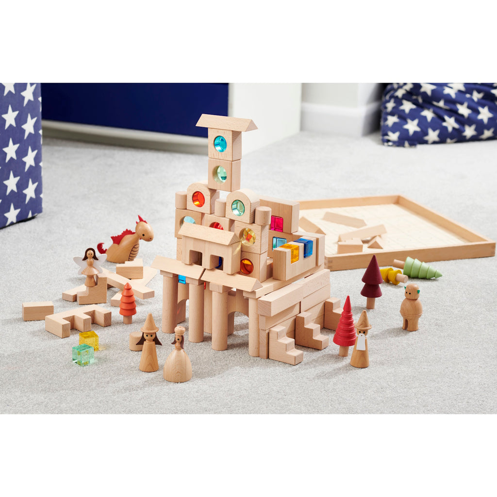 A large collection of wooden construction blocks with embedded colorful gems, designed to encourage creative building, light play, and sensory exploration.