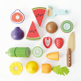 Top-down view of wooden sliceable toy fruits, vegetables, peeler, and knife on a white background.