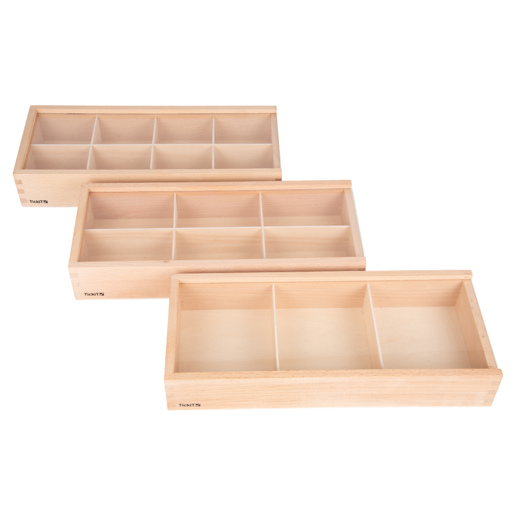 A set of natural wooden boxes with various openings and textures, designed to encourage sensory exploration and fine motor development in young children.