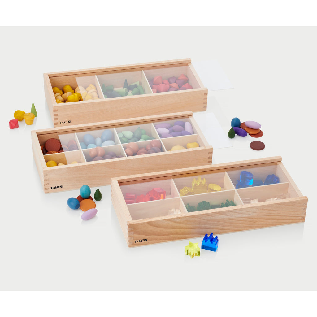 A set of natural wooden boxes with various openings and textures, designed to encourage sensory exploration and fine motor development in young children.