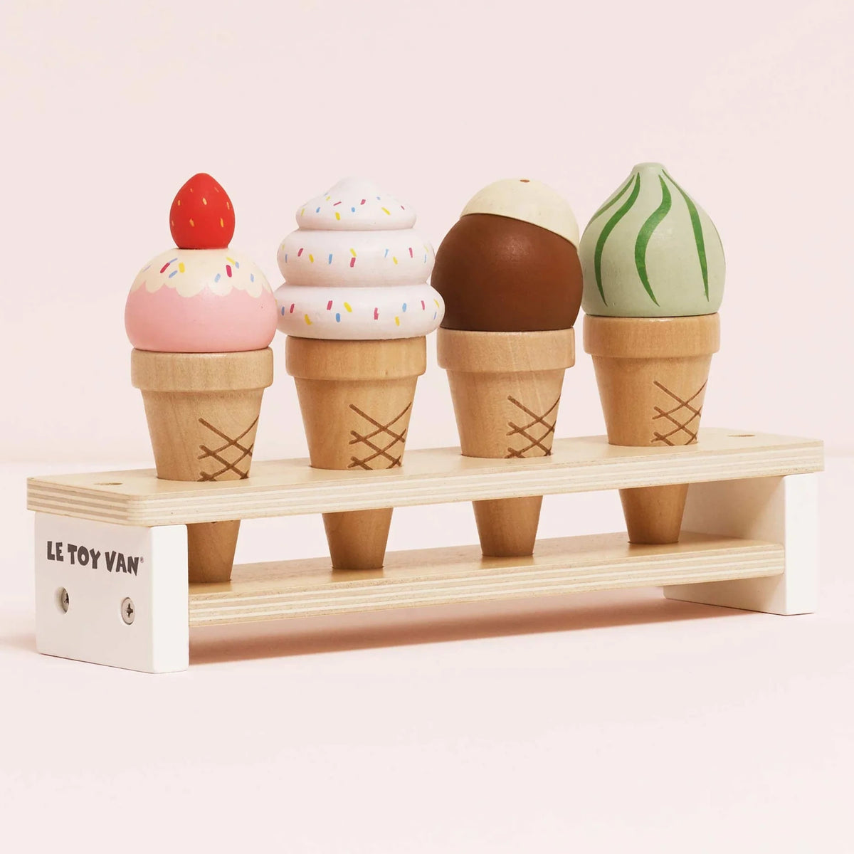 Four wooden toy ice cream cones in different flavors on a display stand.