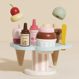 Wooden ice cream stand set with cones, topping bottles, and floating wooden scoops.
