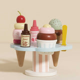 Wooden toy ice cream stand filled with stacked cones, sauce bottles, and colorful scoops.