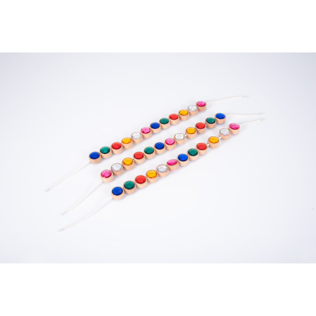 A set of brightly colored wooden gem-shaped beads with holes for threading, designed to develop fine motor skills and hand-eye coordination.
