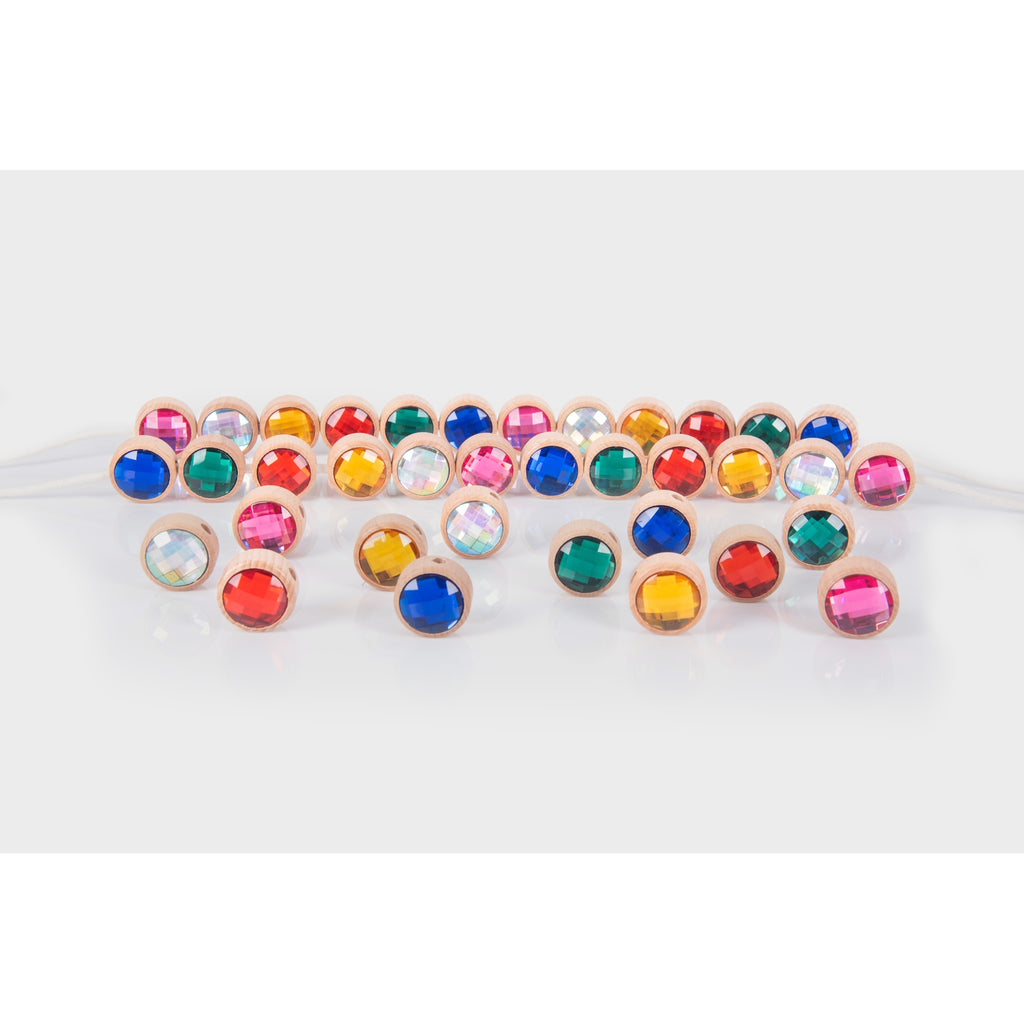 A set of brightly colored wooden gem-shaped beads with holes for threading, designed to develop fine motor skills and hand-eye coordination.