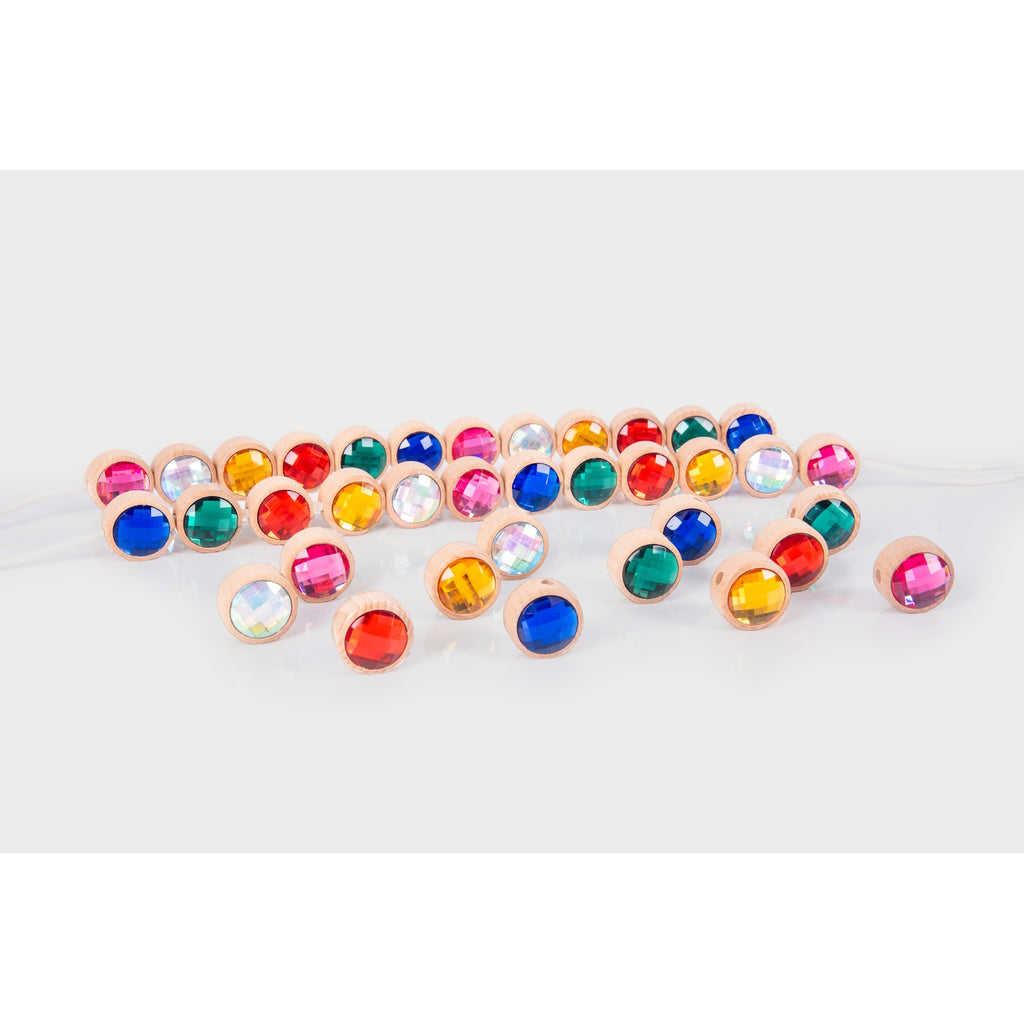 A set of brightly colored wooden gem-shaped beads with holes for threading, designed to develop fine motor skills and hand-eye coordination.