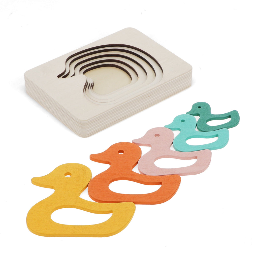 Colorful wooden duck shapes in orange, yellow, pink, and teal, alongside a stack of nested curved wooden pieces.