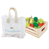 Wooden toy crate filled with play apples and pears next to a Honeybake canvas tote bag.