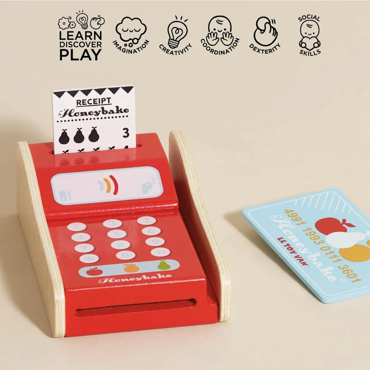 Wooden toy card machine with a receipt, blue payment card, and icons for learning, imagination, and social skills.