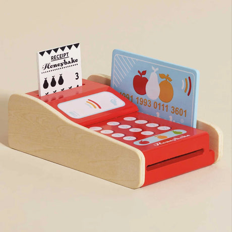 Wooden toy card machine in red and natural wood, with a blue payment card and a printed receipt.