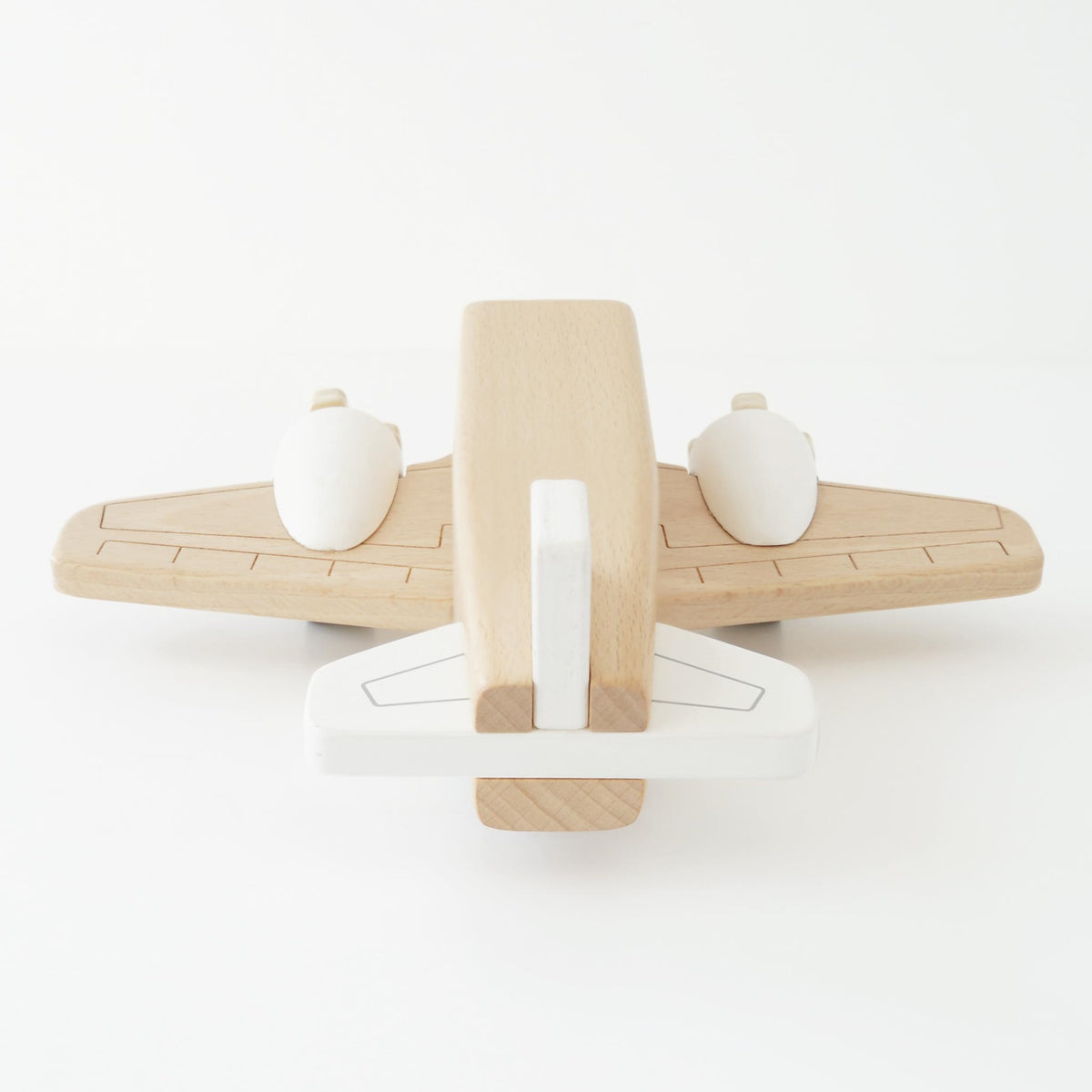 Minimalist natural wood and white toy airplane viewed from behind.