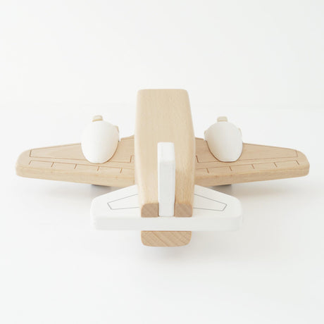 Minimalist natural wood and white toy airplane viewed from behind.