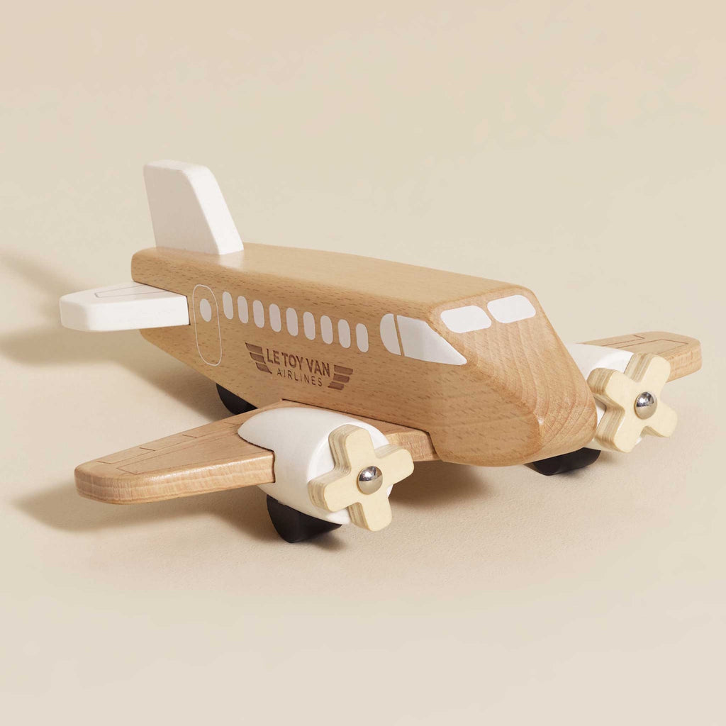 Toy wooden airplane with "Le Toy Van Airlines" logo. Made from smooth wood with white details, creating a classic and playful design.