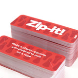 Two stacks of red Zip-it! party game cards showing a card prompt on top.