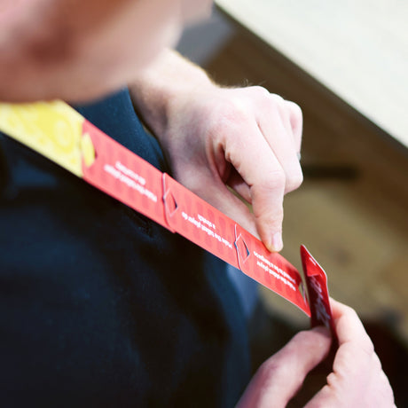 Person interlocking long red Zip-it! party game cards together.