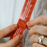 Hands connecting two red game cards together using a slot mechanism.
