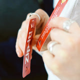 Close-up of a person holding red Zip-it! game cards during play.