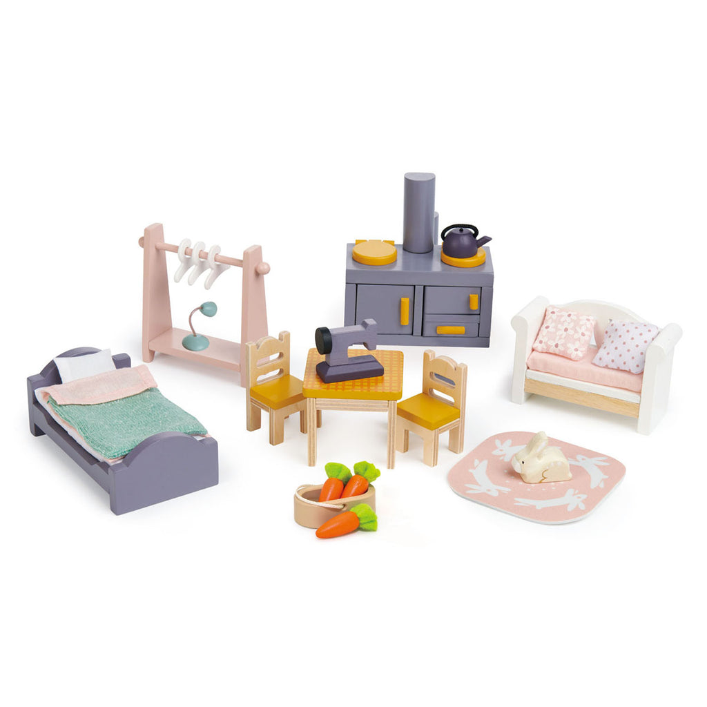 Detail image of Cottontail Cottage wooden dolls house furniture set, which shows wooden bed and bedding , dusty pink clothes rail and hangers, range style cooker with kettle, table with two chairs and a swing machine, sofa with soft cushions and pet rabbit on a mat with a basket of carrots