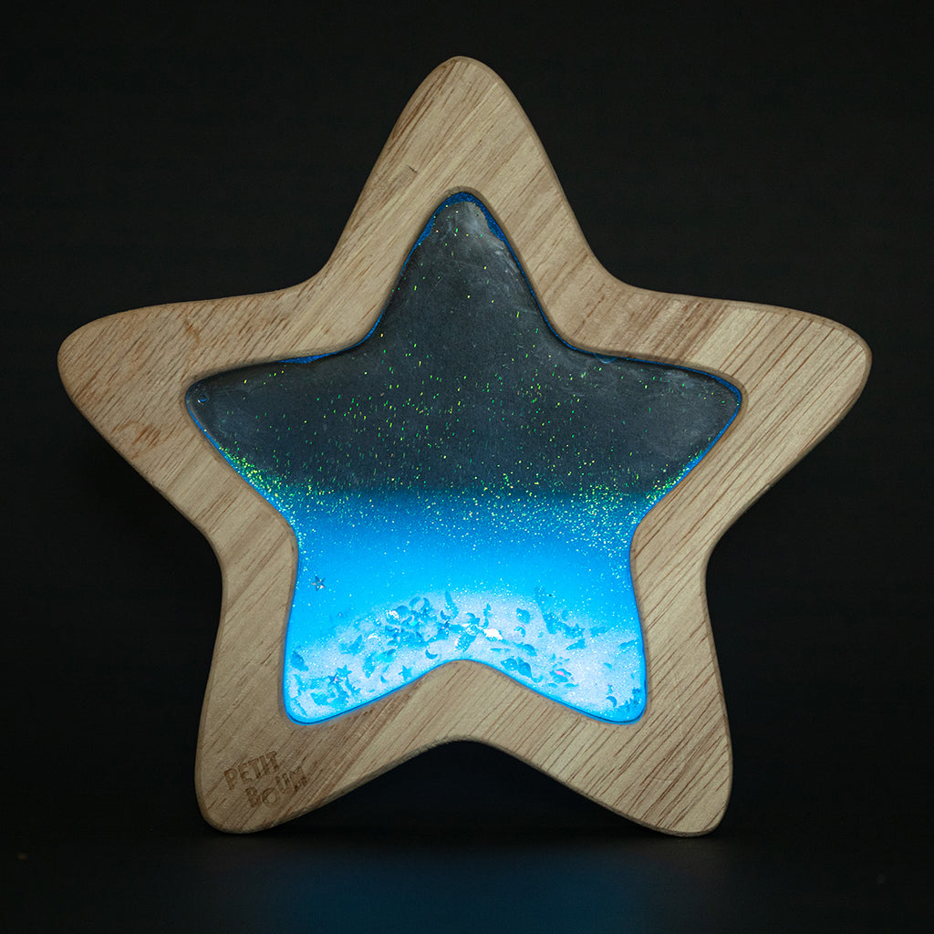 The Flow Star sensory toy glowing in the dark, revealing its sparkling and luminescent effect.